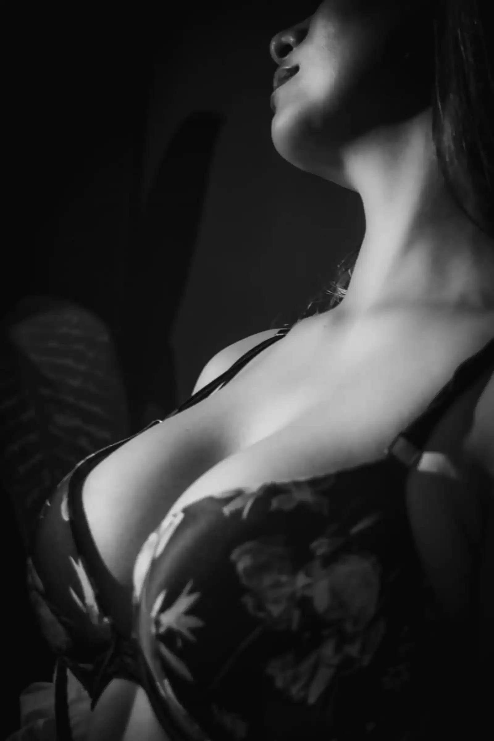 Detalle de torso con lencería negra bajo luz direccional en una sesión de fotografía boudoir con Utopic Dystopia