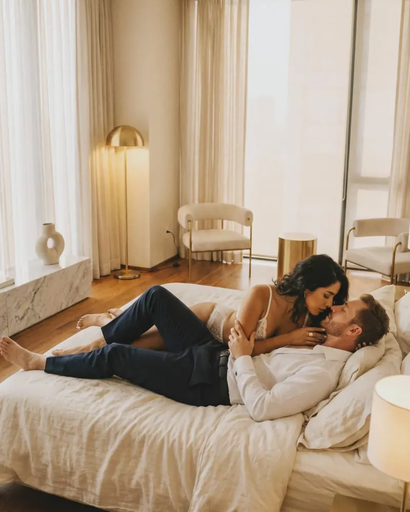 Pareja boudoir recostados en cama con luz dorada íntima CDMX